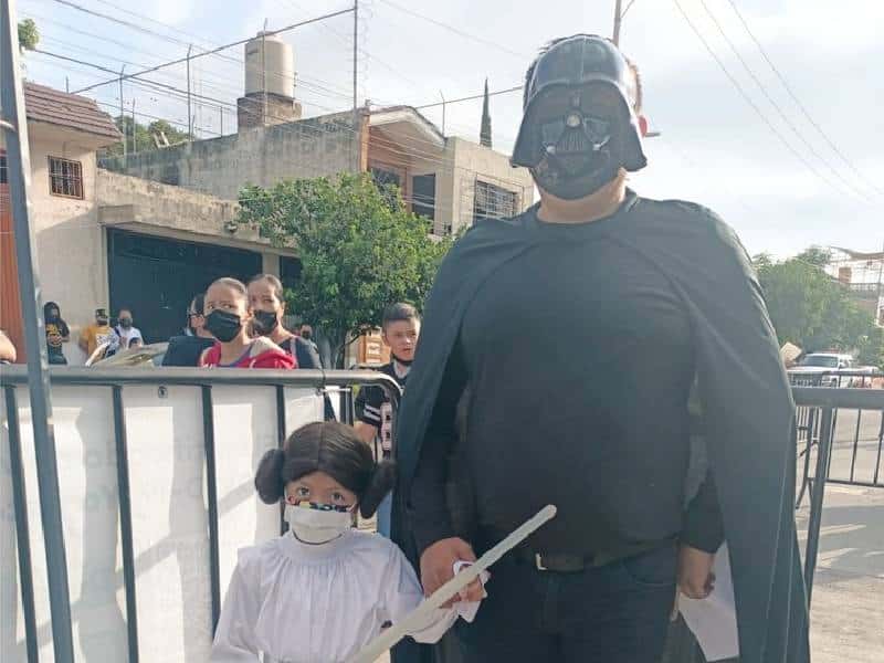 Padre acompaña a su pequeña hija a recibir su vacuna Covid con disfraz de Darth Vader