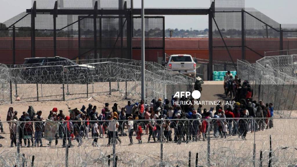 Migrantes hacen fila para ser trasladados por la Patrulla Fronteriza de Estados Unidos después de haber cruzado el río Bravo en El Paso, Texas.