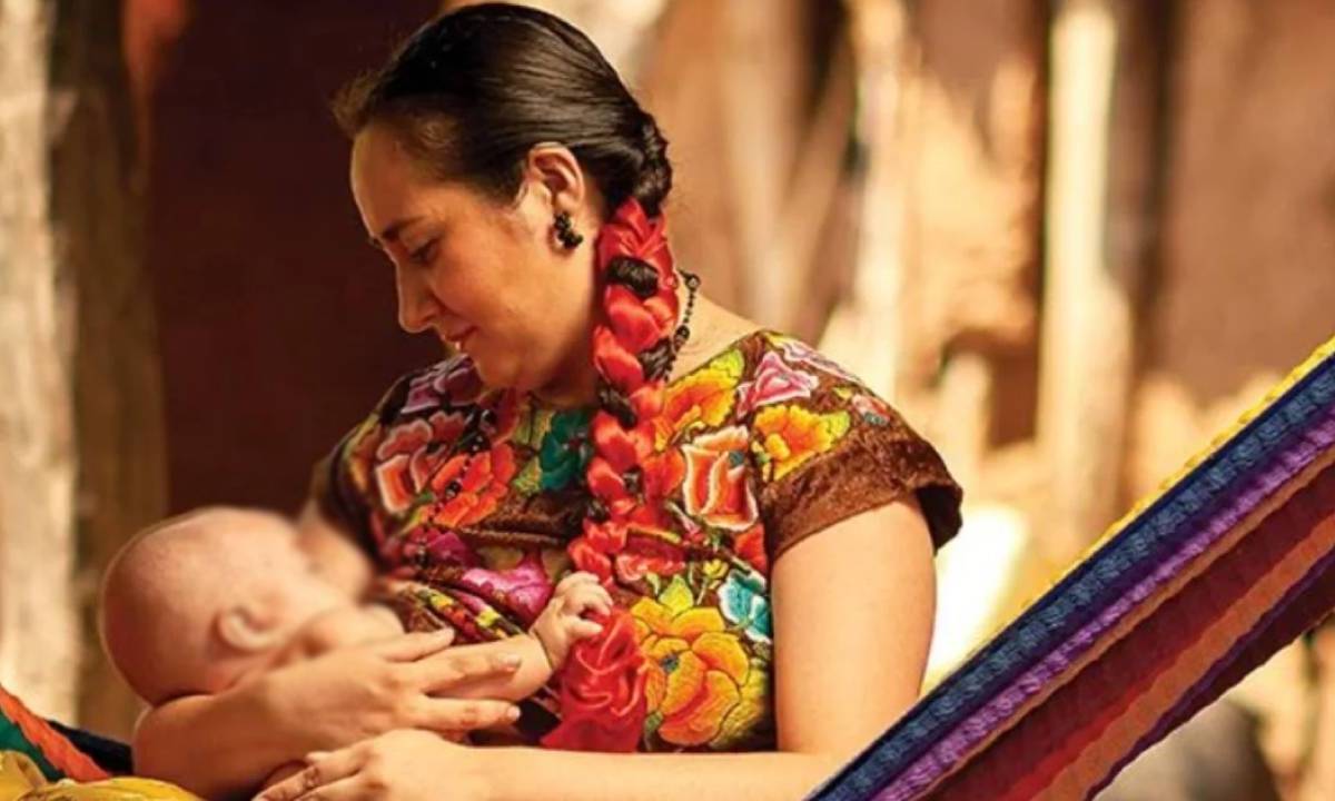 Una madre mexicana abraza a un bebé.