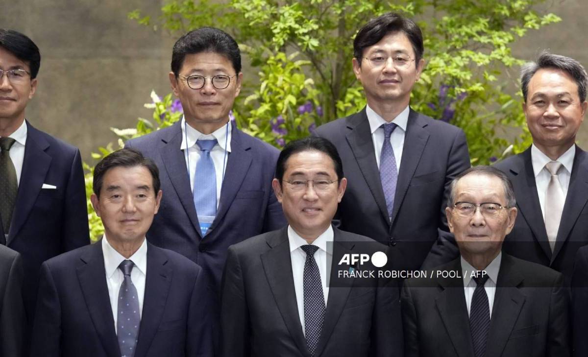 El primer ministro japonés, Fumio Kishida (centro), posa con Kim Yoon (i), presidente de la Asociación Económica Corea-Japón, y su homólogo japonés, Mikio Sasaki (derecha).