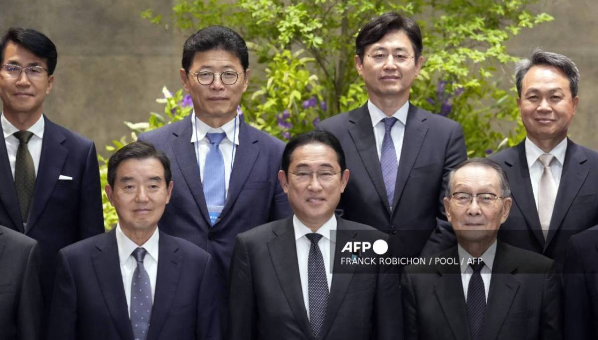 El primer ministro japonés, Fumio Kishida (centro), posa con Kim Yoon (i), presidente de la Asociación Económica Corea-Japón, y su homólogo japonés, Mikio Sasaki (derecha).