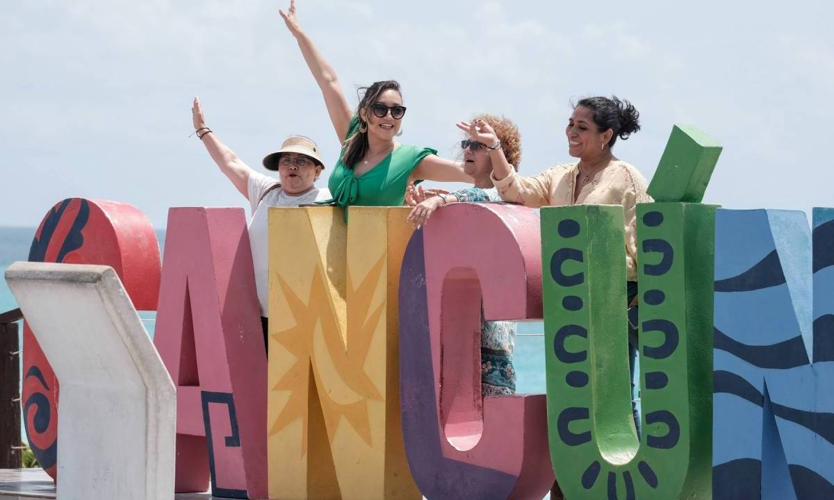 Turistas disfrutan del calor y posan en parador fotográfico de Cancún,