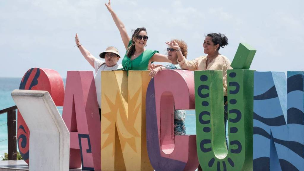 Turistas disfrutan del calor y posan en parador fotográfico de Cancún,