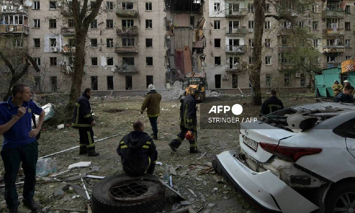 Los rescatistas trabajan en el lugar de un ataque con misiles en Lugansk, Ucrania controlada por Rusia.