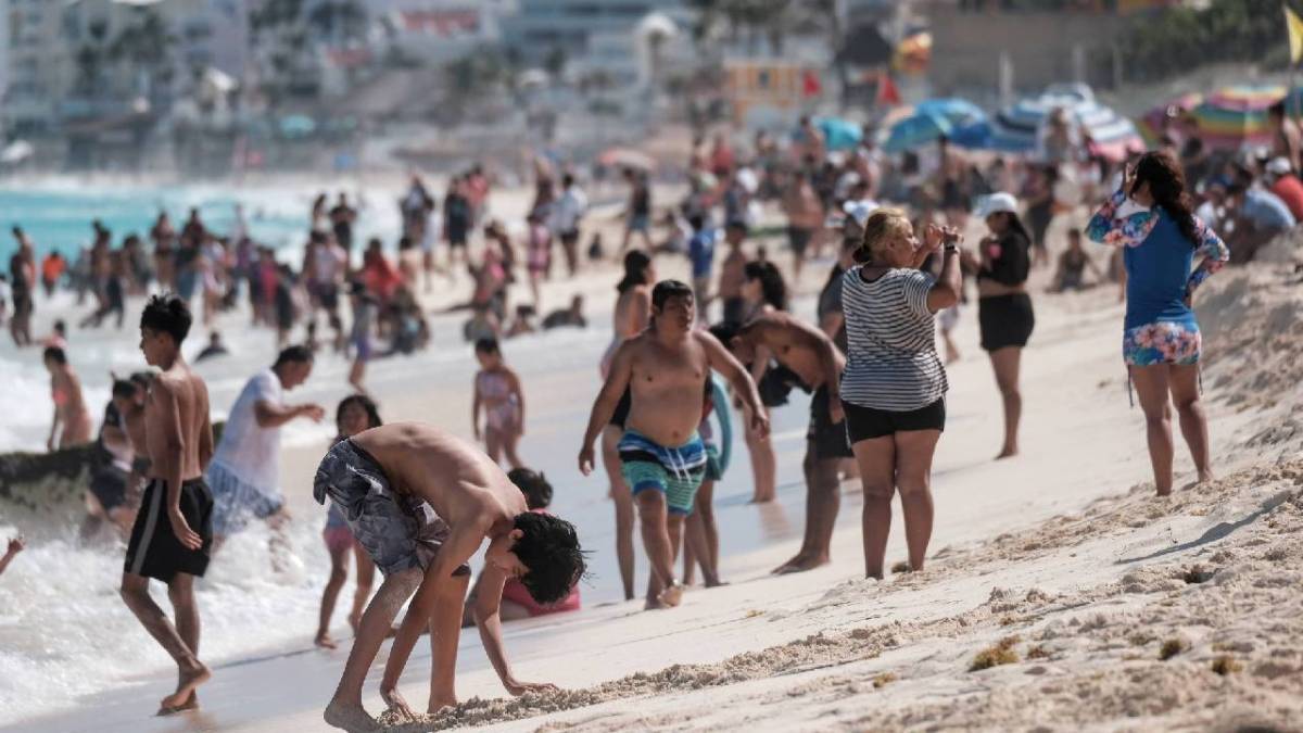 Una playa de Cancún se ve atiborrada de bañistas.