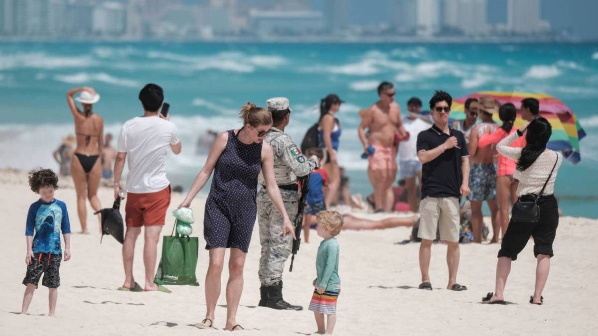 Turistas disfrutan de una playa en Cancún.