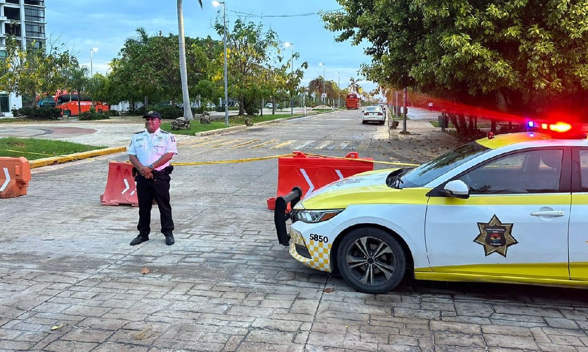Policía de tránsito vigila un cierre vial en Cancún.