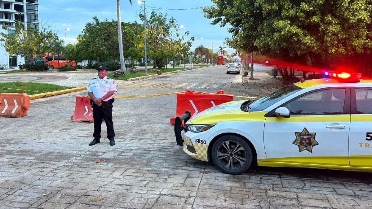 Policía de tránsito vigila un cierre vial en Cancún.