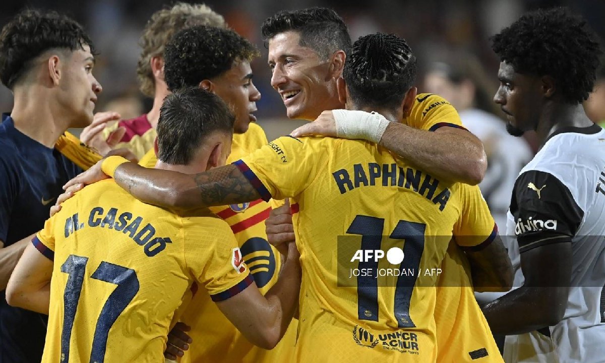 El delantero polaco del Barcelona #09 Robert Lewandowski (C) celebra con sus compañeros junto al defensor portugués del Valencia #12 Thierry Correia.