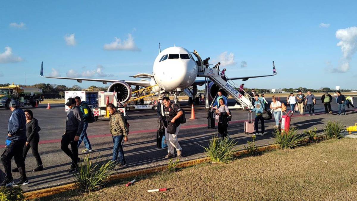 Turistas bajan del avión en Cancún.