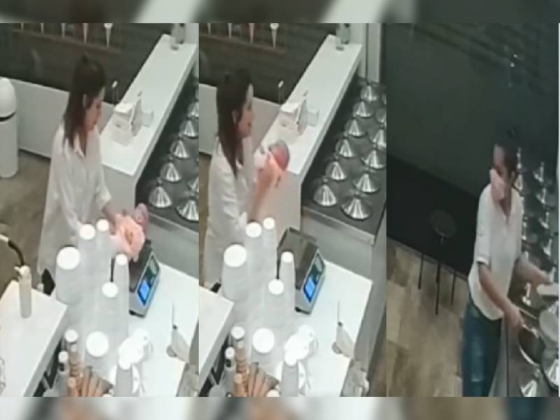 Cachan a mujer pesando a su bebé en la báscula de una heladería