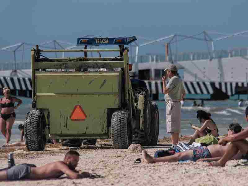 Maquinaria antisargazo cerca de los turistas