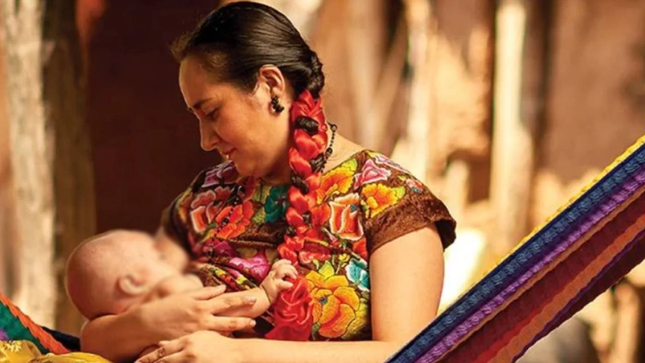 Una madre mexicana abraza a un bebé.