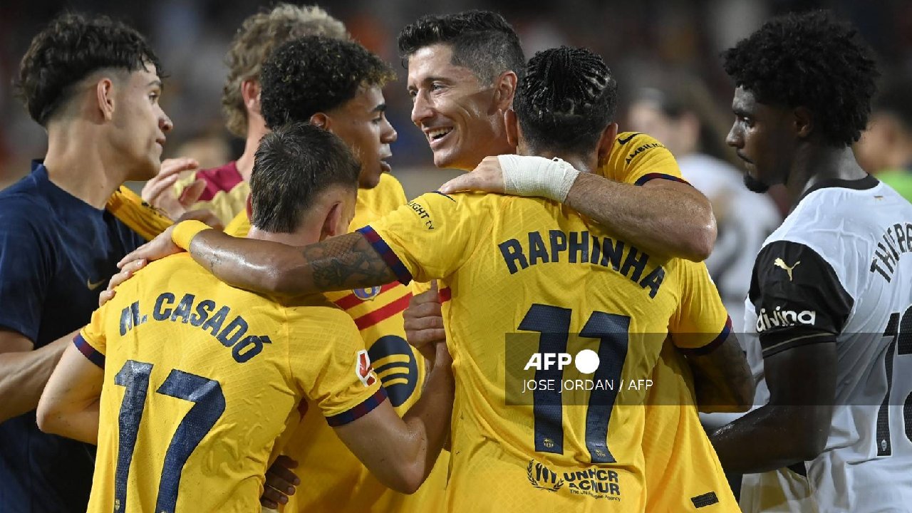 El delantero polaco del Barcelona #09 Robert Lewandowski (C) celebra con sus compañeros junto al defensor portugués del Valencia #12 Thierry Correia.