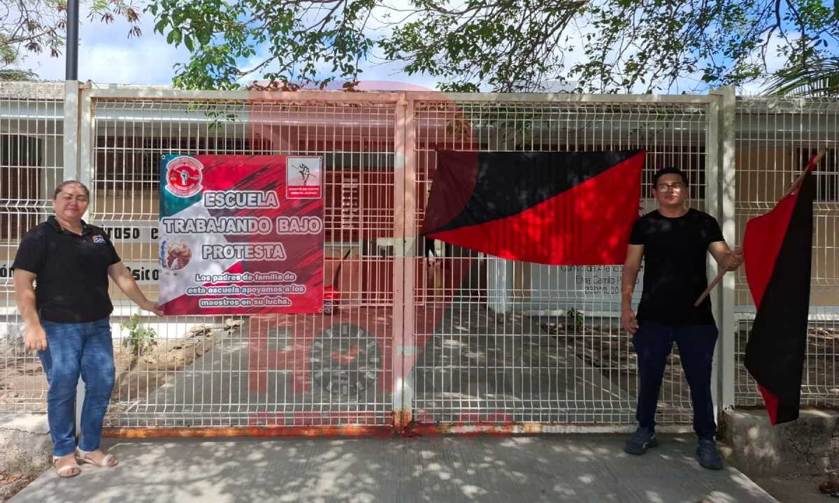 Banderas rojinegras en escuelas de Cancún.