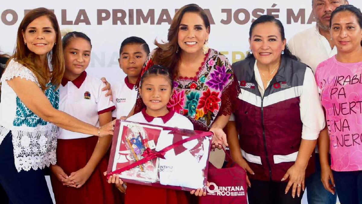 Mara Lezama entrega mochilas.