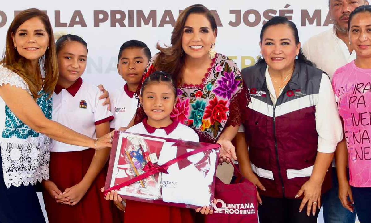 Mara Lezama entrega mochilas.