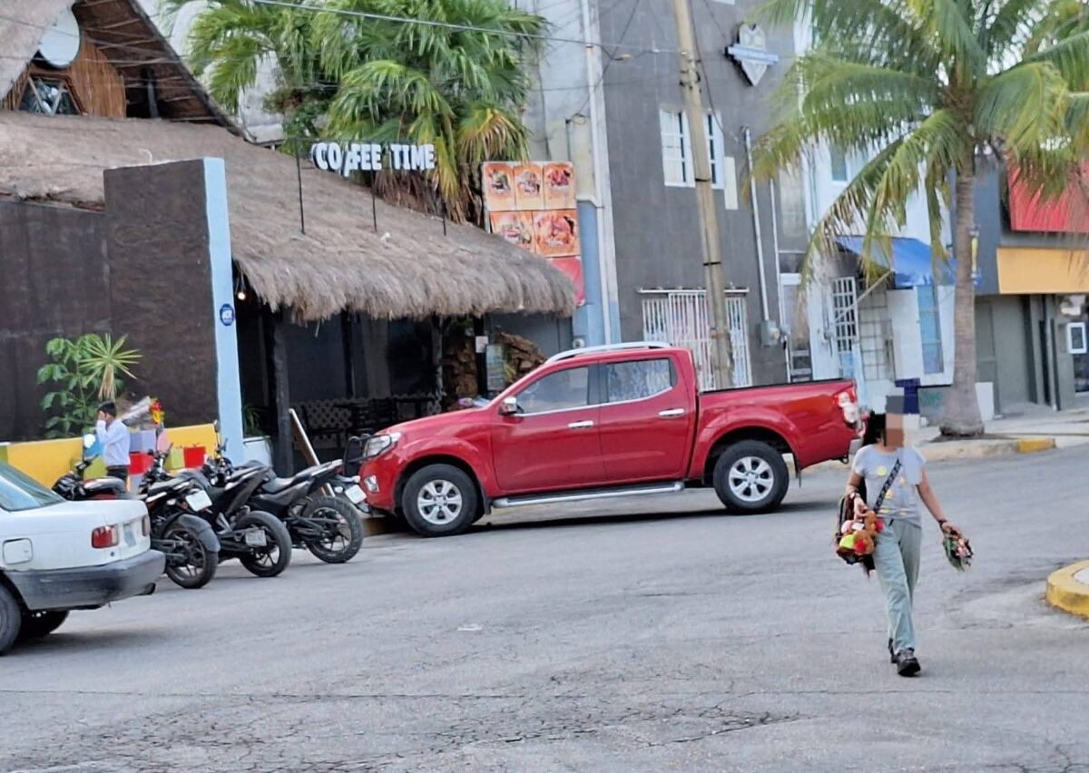 Elena es una menor de 12 años, en la imagen se le observa caminando por calles céntricas de Cancún donde ofrece artesanías a turistas y paseantes locales, para ayudar a su familia.
